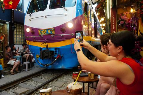 A close-up of a train passing by as people take photos.