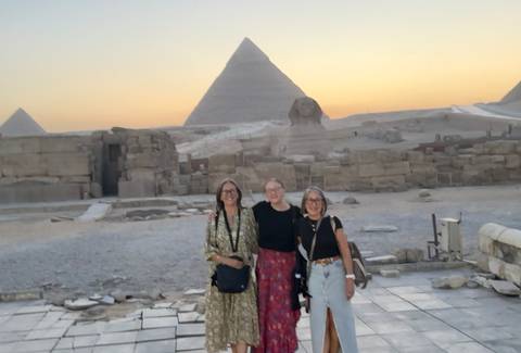 Three women at the Pyramids during sunset.