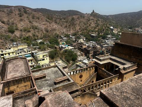 Aerial view of a fort complex and surrounding town in a hilly area.
