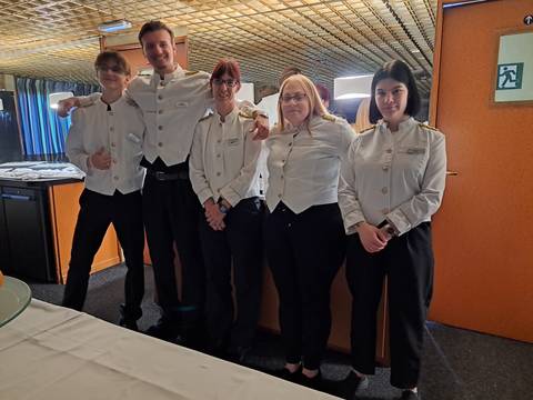 Group of people in uniforms posing indoors.