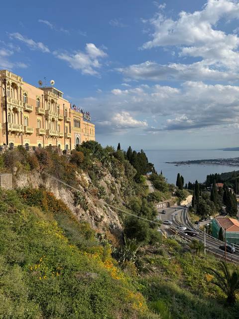 Majestic view of a hillside villa overlooking the sea.