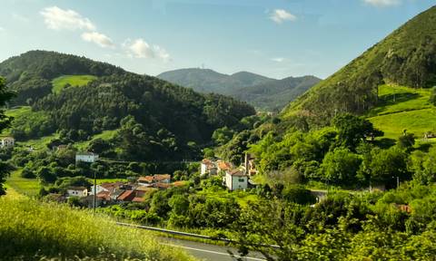 A quaint village nestled within lush green hills.