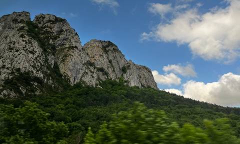 Mountains with thick vegetation under a clear blue sky.