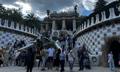 A crowded tourist spot with intricate architecture and stairs.