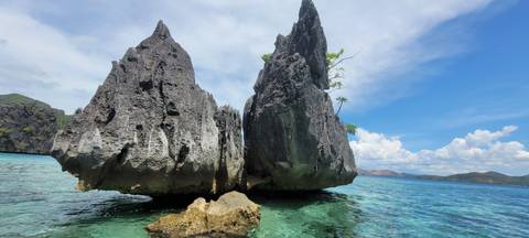       Sharp rock formations rising from turquoise waters.
  