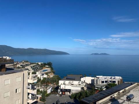 Coastal view with buildings and mountains in the distance.