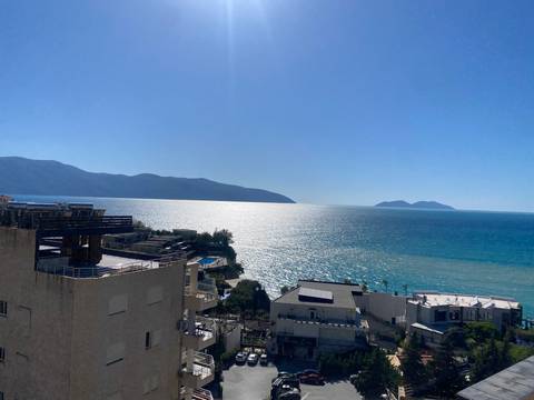 A view of the sea with mountains and sky in the background.
