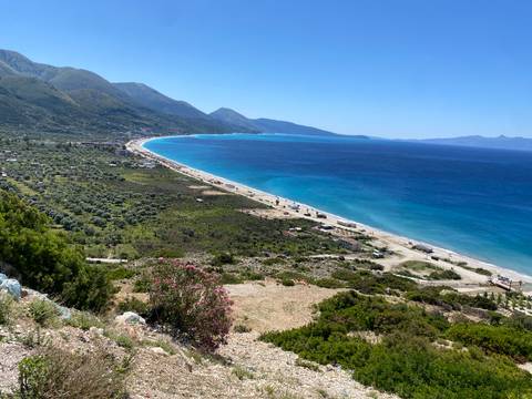 A panoramic view of a coastal landscape with mountains.