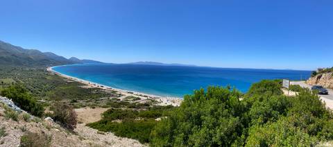 A wide view of a coast with a clear blue sea and sky.