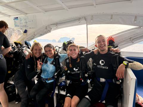 A group of divers on a boat preparing for a dive.