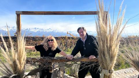       A couple posing with straw decorations in a vineyard.
  