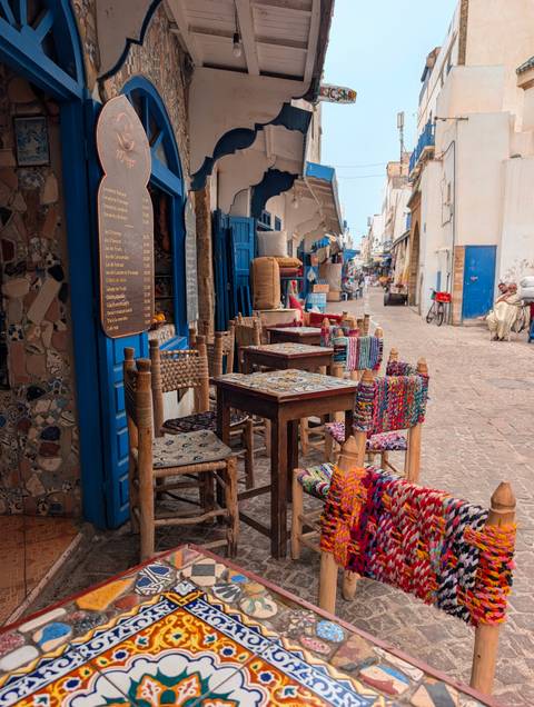 Colorful street with vibrant chairs and menu.