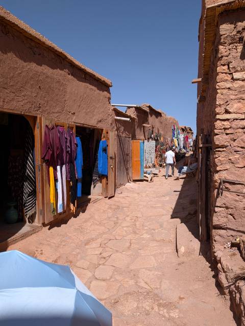 Market street with colorful textiles and shops.