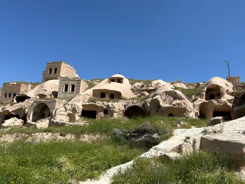 Rock formations and ancient dwellings on a hillside.