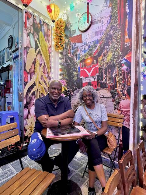 Couple sitting at a cafe with vibrant outdoor setting.