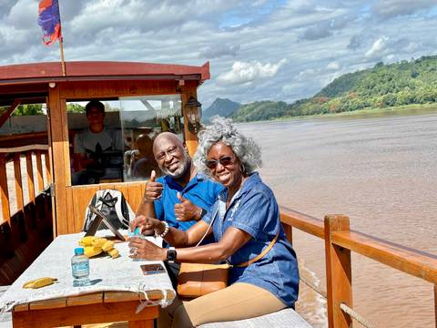       Couple enjoying a ride on a boat along a river.
  