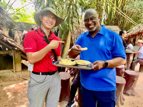       Two people enjoying snacks in a rural setting.
  