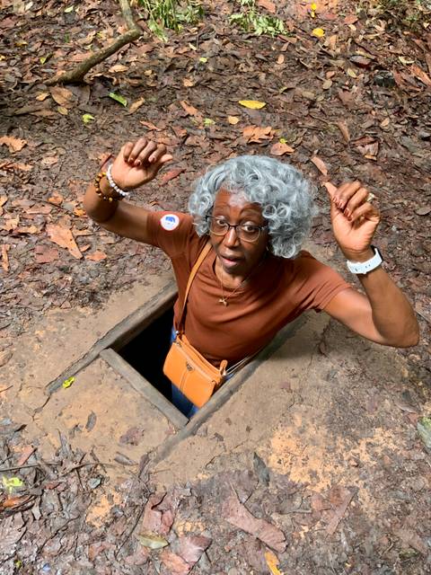 Monks in orange robes walking down a street with offerings.