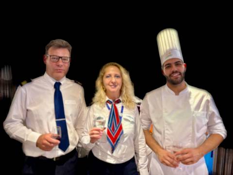 Three people posing in uniforms with glasses.