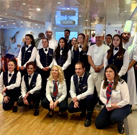 Group of crew members in uniforms posing together.