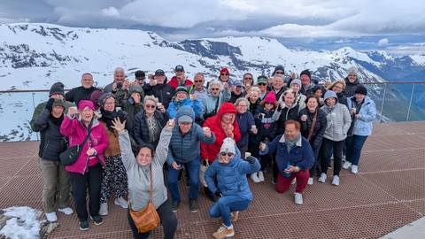       People celebrating with snowy mountains in the background.
  