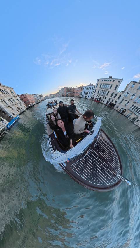 People on a boat traveling through the canals of Venice, Italy.