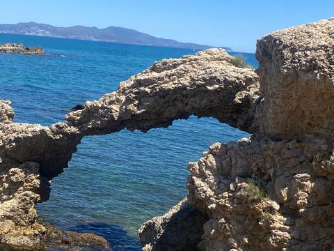 Rock formation arch by the blue sea.