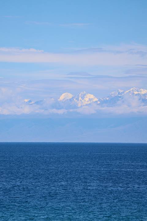       Snow-capped mountains viewed across a lake.
  