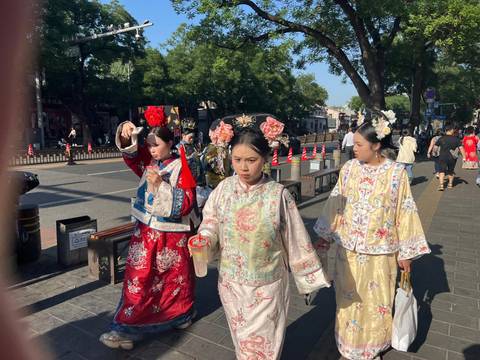 Women in traditional dresses walking down a street.
