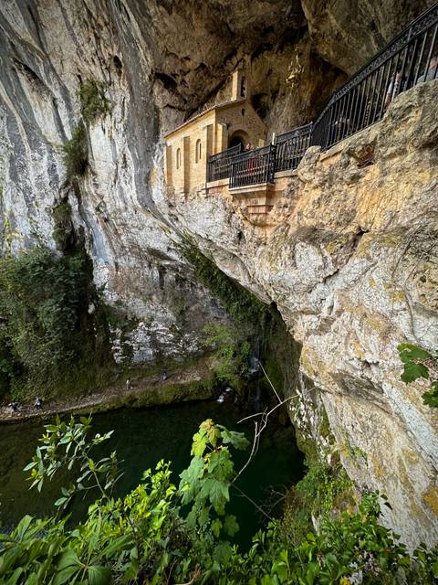       Rocky cliff with a sacred site built into the side.
  