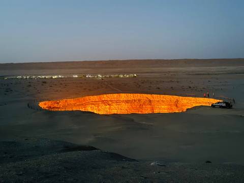       Distant view of the Darvaza Gas Crater glowing at night.
  