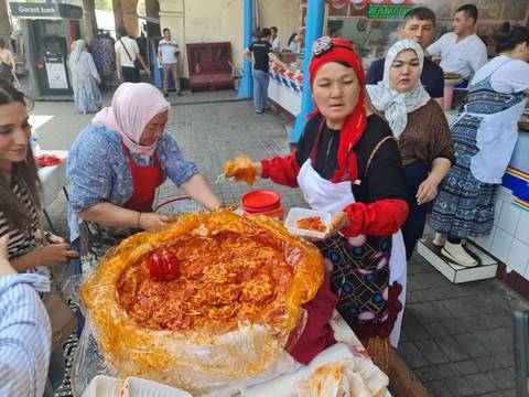       Women preparing and selling traditional foods at a market.
  