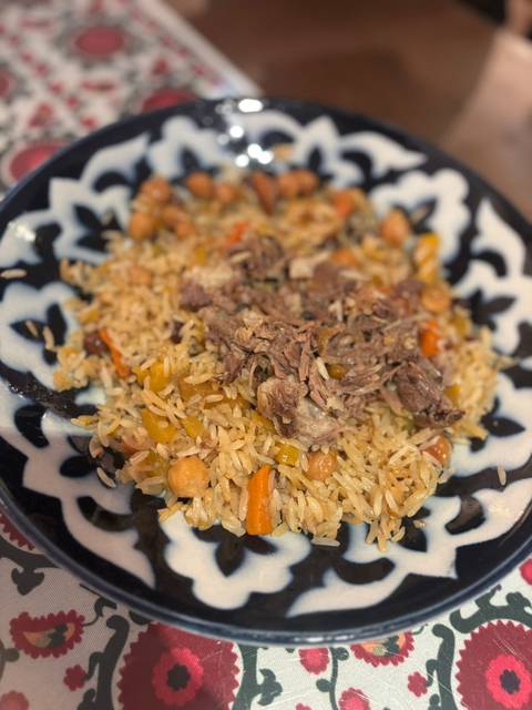       A plate of traditional rice dish with meat and vegetables.
  