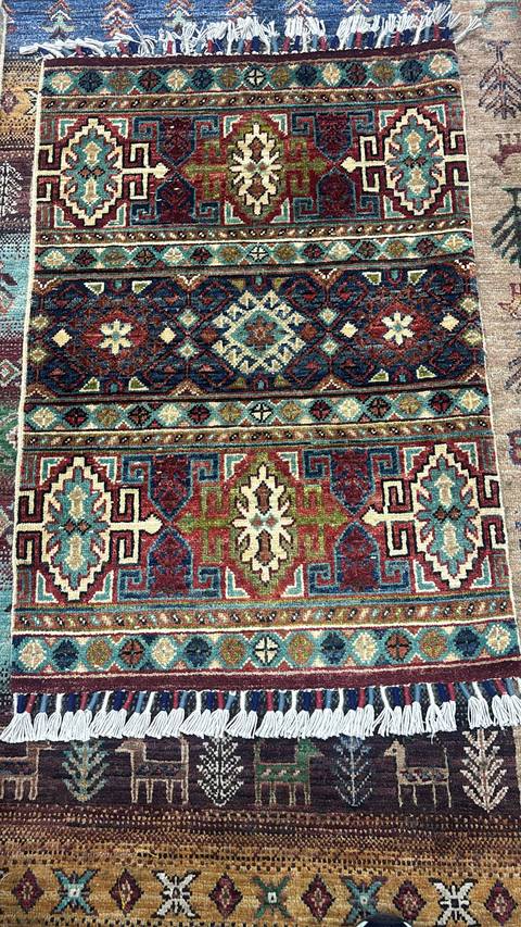       Intricate designs on a colorful woven carpet.
  