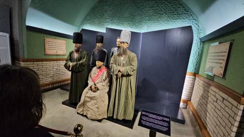       Costumed mannequins depicting historical figures in a museum setting.
  
