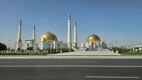       Magnificent white and gold mosque with multiple minarets.
  