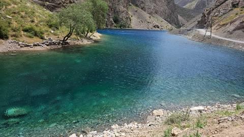       Scenic view of a clear blue lake with rocky shores and mountains.
  