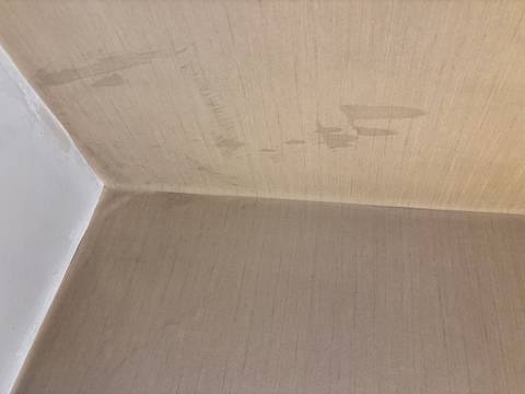 Corner of a room with stained wallpaper.