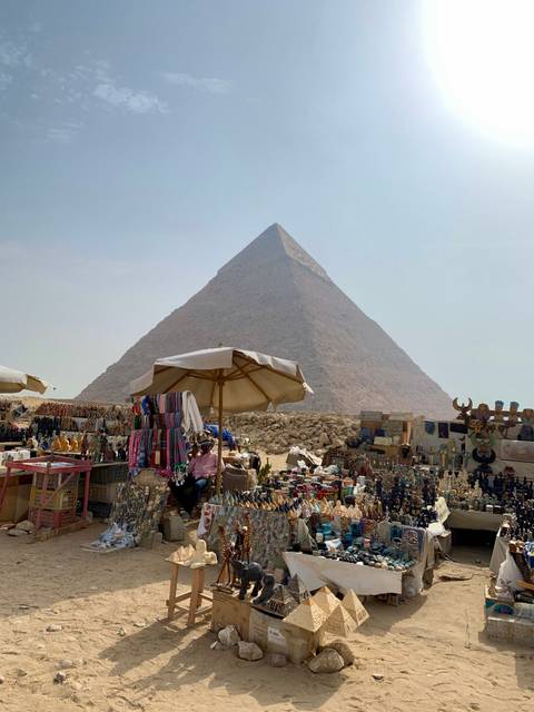 Tourist marketplace with souvenirs in front of a pyramid.