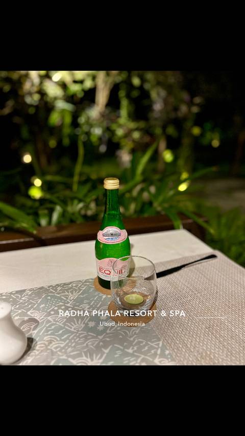       Bottle of Equil water on a table with greenery in the background.
  