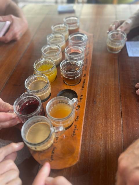       Various teas served in small cups on a wooden tray.
  