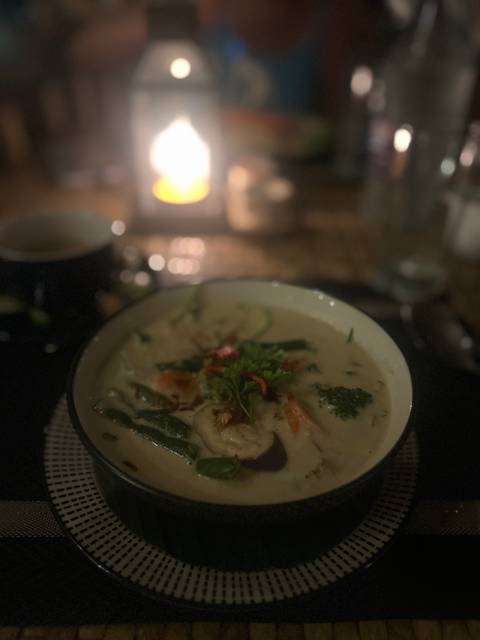 Close-up of a soup dish under dim light.