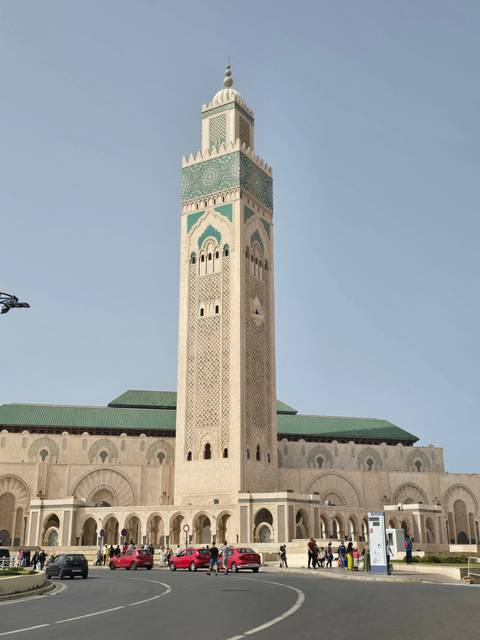 Tall mosque minaret under clear sky.