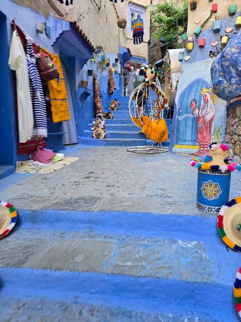 Blue street with colorful decorations and stairs.
