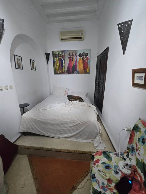 Small, white, minimalistic bedroom with a double bed.