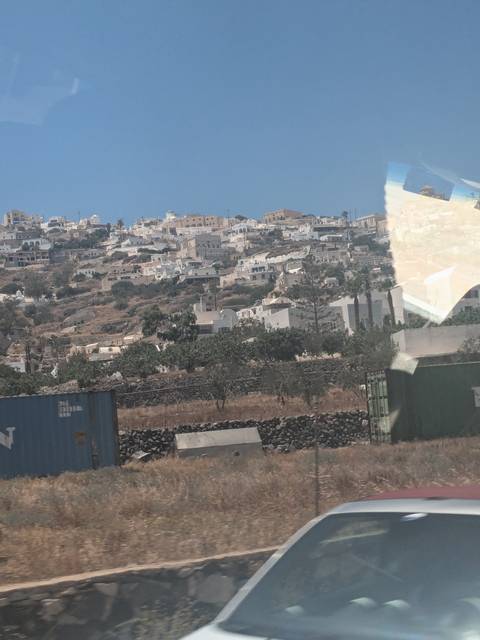       Hilly landscape with scattered houses and a visible cargo container.
  