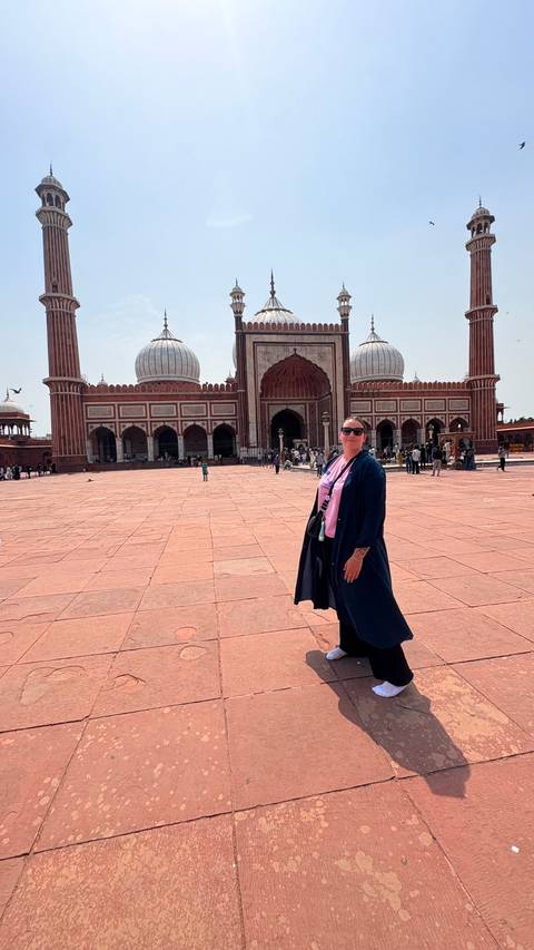 Woman posing in front of a large historical mosque.