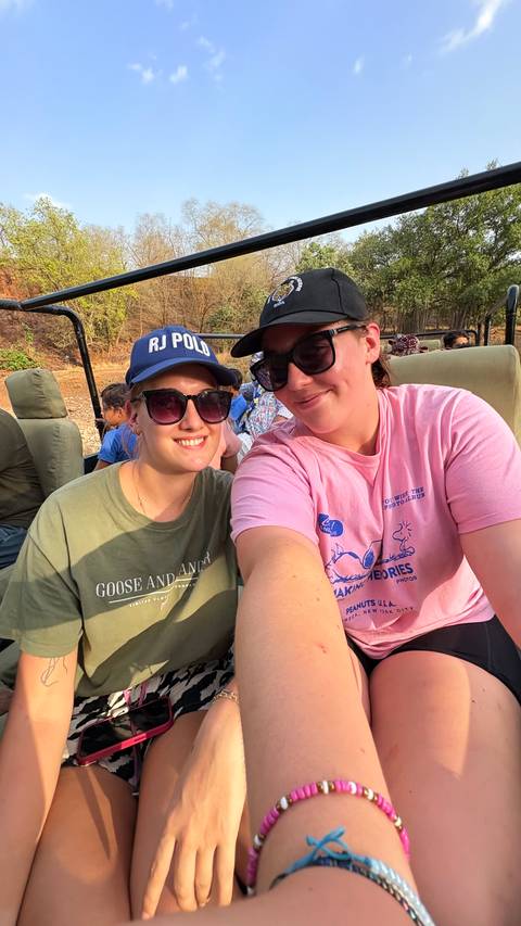       Two women on a safari vehicle enjoying the ride.
  