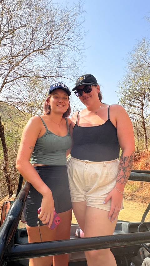       Two women posing in a natural outdoor setting.
  