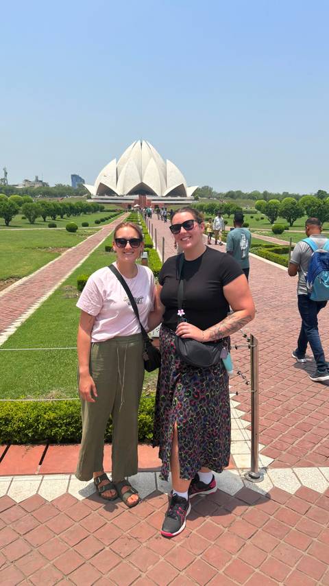 Two women posing in a garden with pathways.